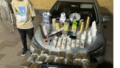 المتهم وأمامه المضبوطات
